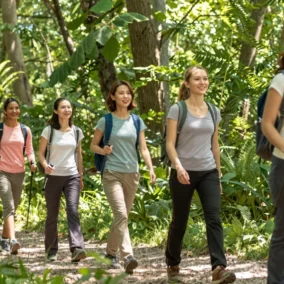 Hiking Trousers for Ladies That Don't Feel Like Canvas Sacks 14 A group of happy women wearing hiking trousers for ladies, enjoying a day out in nature.